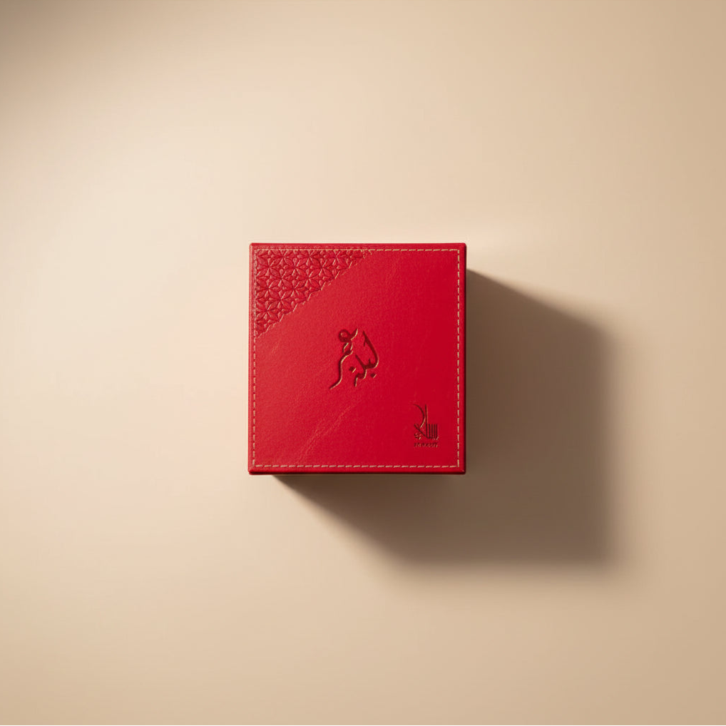Red jewelry box with a drawer containing a ring and a bottle of perfume on a gray background