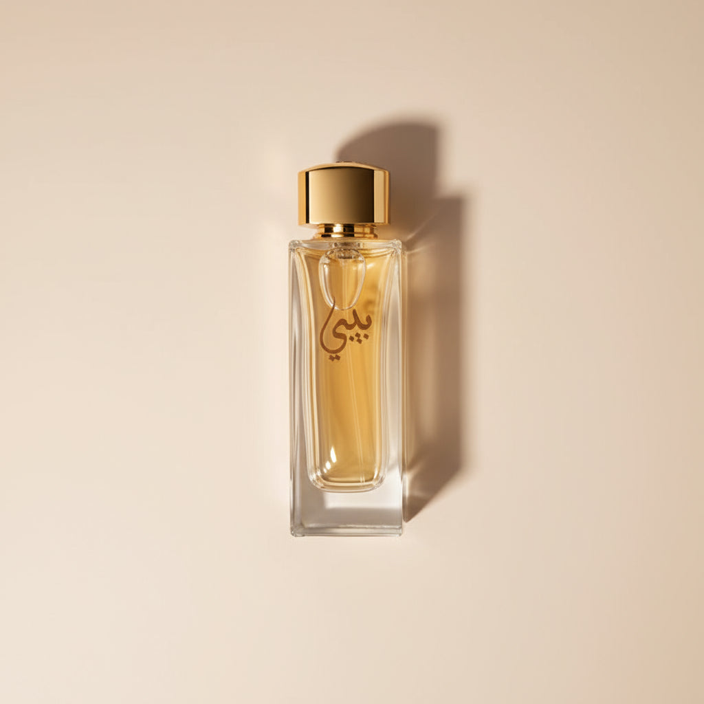 Perfume bottle with gold cap and black box featuring Arabic text on a white background