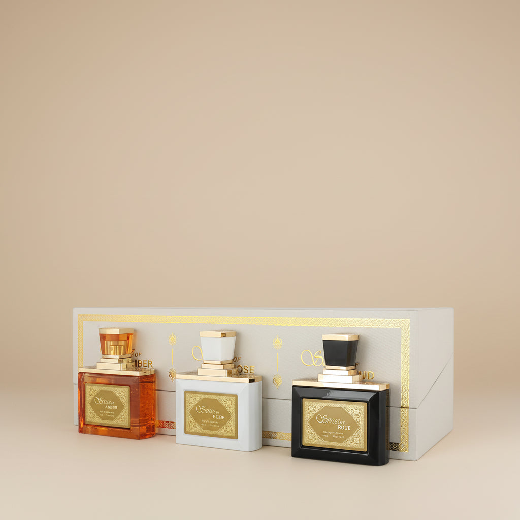 Three perfume bottles in a decorative box on a white background