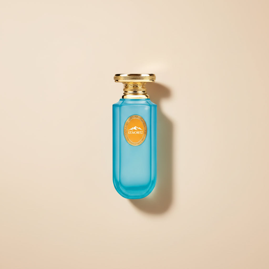 Blue perfume bottle with gold cap and 'St. Moritz' label against a mountain landscape background