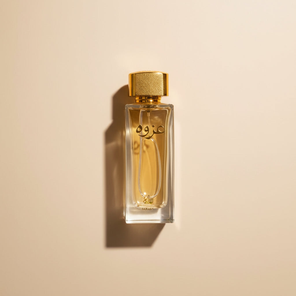 Perfume bottle with gold cap and black box featuring Arabic text on a white background